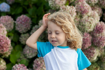 Cute small child with many flowers in the garden