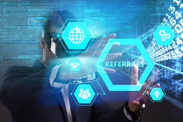 Business, Technology, Internet and network concept. Young businessman working in virtual reality glasses sees the inscription: Referrals