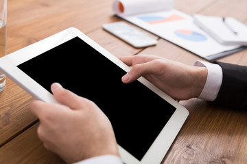 Male using digital tablet, close up, side view,