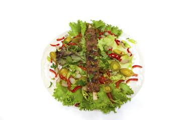 kebab on fresh salad isolated on white background