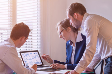 Team of finance people discussing charts and KPI, computer screen