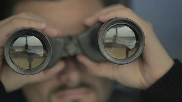 Dispatcher controls the air-traffic with binoculars in airport in control tower