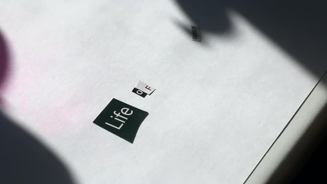 Crime. An attacker in rubber gloves glues on a piece of paper the letters and words cut from different editions. Compilation of a letter with threats.