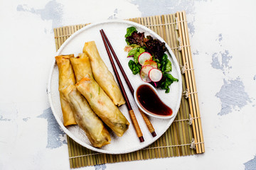 Fried spring rolls with vegetables, duck meat and noodle on white stone table. Copy space. Top view