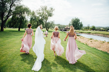 The bride and friends are running on the grass