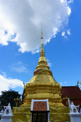 Fototapeta premium golden pagoda with blue sky and cloud, pong sanuk temple, lampang, thailand.