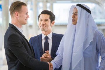 business agreement between arabian and white guy at building outdoor
