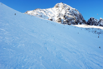 Fototapeta na wymiar Skiers on mountain slope in winter sunny day in High Tatras.