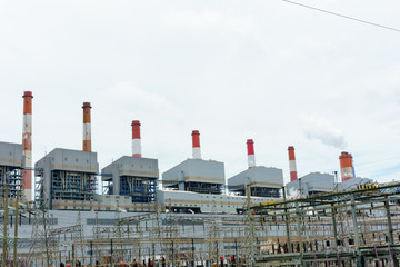 Obraz premium high voltage electricity station and 500 KV pylon and group of coal fired power plant and stack with blue cloudy sky, electricity concept