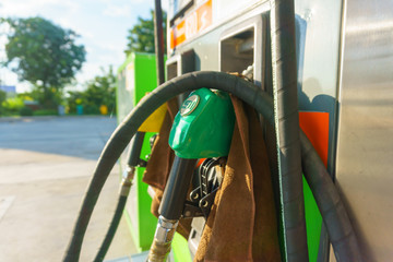 petrol pump nozzle for fill fuel at gas station in sunny day