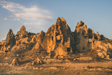 Natural volcanic rocks with ancient cave houses in Goreme Open Air museum in Cappadocia, Central Anatolia region of Turkey, at sunset on clear day