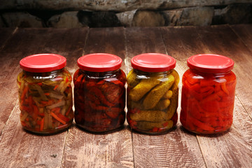 Jar with variety of pickled vegetables. Carrots, field garlic, parsley in glas. Preserved food. Fermented preserved vegetarian food concept. Canned food