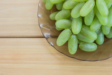 grapes in plate on wooden table