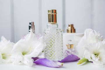 Obraz na płótnie Canvas different bottles of perfume with white flowers