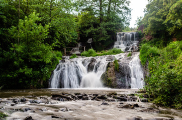 Obraz premium Cascaded waterfall in a green forest. Dzhurinsky waterfall Ukraine.