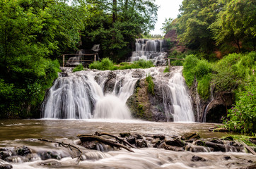 Fototapeta na wymiar Cascaded waterfall in a green forest. Dzhurinsky waterfall Ukraine.