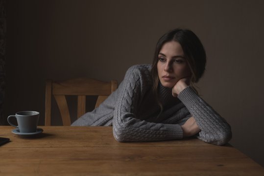 Thoughtful Woman Leaning On Table