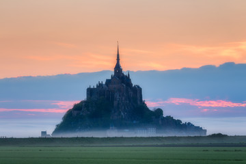 Panoramic view of famous Le Mont Saint-Michel tidal island in beautiful sunrise foggy light,...