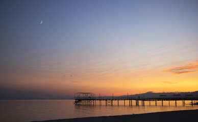 Colorful Sunset and moon from over pier