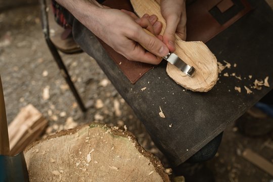 Mid section of carpenter making wooden spoon