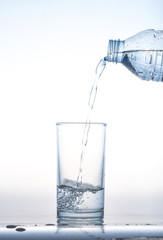 pouring water on a glass on white background,Glass of water, Glass of water isolated on white background,Water pouring from bottle into the glass, isolated on white