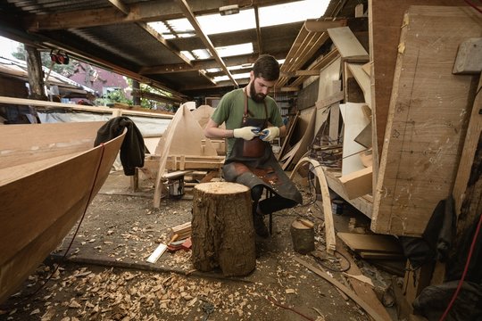 Carpenter shaping wood in workshop