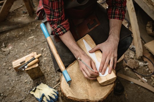 Mid section of carpenter making wooden spoon