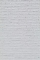 Solid old brick wall with white paint