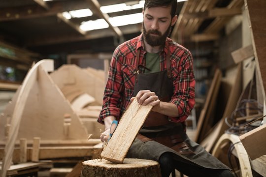 Carpenter cutting wooden log