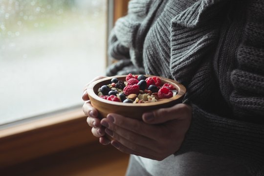 Woman Holding Bowl Of Berries At Home