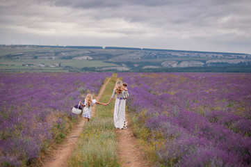 Walking mom and daughters in the field of lavender