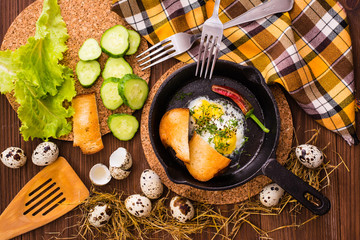 Fried quail eggs in a iron pan. Top view