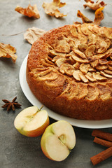 Apple cake with cinnamon and star anise on grey wooden table