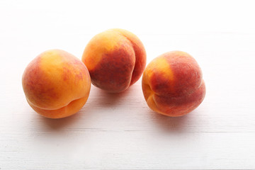 Ripe peaches fruit on white wooden table