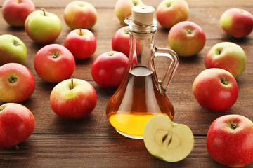 Apple vinegar in glass bottle on brown wooden table