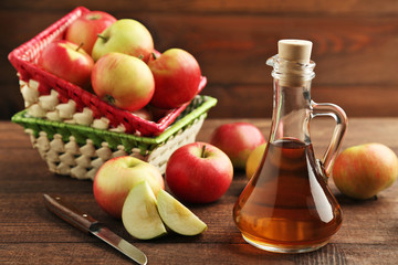 Apple vinegar in glass bottle on brown wooden table
