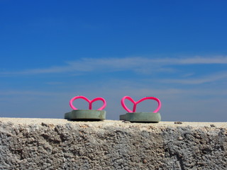 Badeurlaub: Rosa Kinder-Flip-Flops auf Kaimauer