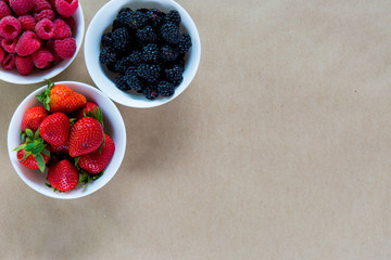 Small white bowls filled with ripe berries.