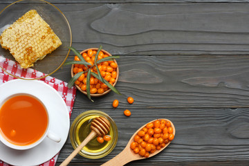 Sea buckthorn in wooden bowl, honey, Sea buckthorn juice on wooden table. top view with copy space