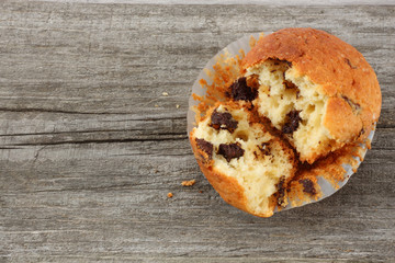 muffin with chocolate on old wooden table. top view