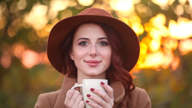Video of Young woman with cup of coffee or tea at autumn outdoor