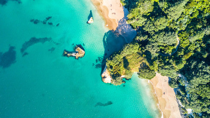 Obraz premium Aerial view on a small beach surrounded by rocks and forest. Coromandel, New Zealand