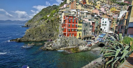 Fototapeta na wymiar View of the colorful houses in a sunny day in Riomaggiore, Italy on April 14, 2016. Riomaggiore is one of the five famous Cinque Terre villages