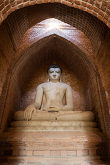 Statue of sitting Buddha inside an untitled temple (historic ruin 446) in Bagan, Myanmar (Burma).