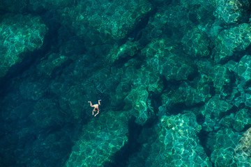 Fototapeta na wymiar Drone view of a woman snorkeling in the sea