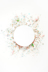 Creative round layout with copy space made of colorful confetti on white background. Celebration concept background. Flat lay, top view.