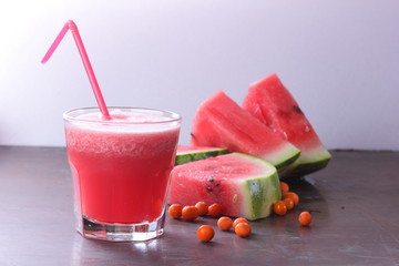 Watermelon cocktail and slices of watermelon on an old rusty background