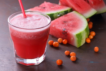 Watermelon cocktail and slices of watermelon on an old rusty background