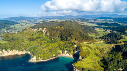 Aerial view on a remote ocean coast with small coves and mountains on the background. Coromandel, New Zealand.