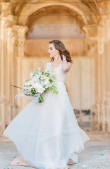 pretty bride woman in elegant white lace dress with wedding bouquet